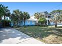 Charming blue home with well-manicured lawn, mature palm trees, and a long driveway at 1415 Edge Dr., North Myrtle Beach, SC 29582