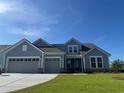 Charming two-story home with blue siding, dual garage doors, and a well-manicured front lawn at 1430 Crested Iris Way, North Myrtle Beach, SC 29582