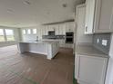 Open kitchen featuring white cabinetry, an island with sink, and stainless steel appliances at 1430 Crested Iris Way, North Myrtle Beach, SC 29582