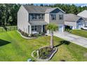 Aerial view of home with well manicured lawn, landscaping, and two-car garage at 1748 Promise Pl., Myrtle Beach, SC 29588