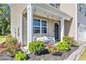 Charming front porch featuring a cozy swing and well-maintained landscaping at 1748 Promise Pl., Myrtle Beach, SC 29588