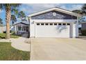 A white garage door is attached to the house with well-maintained landscaping and a walkway to the front door at 1755 Fairbanks Dr., Conway, SC 29526