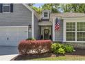 Charming front entrance with an American flag, stylish wreath, and well-manicured landscaping at 199 Gilman Rd., Pawleys Island, SC 29585