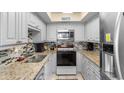 Efficient kitchen with white cabinets, granite countertops, and stainless steel appliances at 201 S Ocean Blvd., North Myrtle Beach, SC 29582