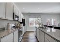 Open kitchen features granite countertops, stainless appliances, and a bright window over the sink at 246 Mayflower Dr., Calabash, NC 28467