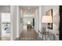 Inviting foyer with wood flooring, elegant console table, decorative lighting, and views into the living area at 309 Glacier Way, Conway, SC 29526