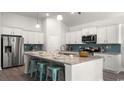 Modern kitchen boasts stainless steel appliances, a large island with seating, and ample counter space at 309 Glacier Way, Conway, SC 29526