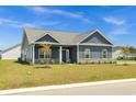 Well-maintained home with blue siding, stylish shutters, landscaped yard, and healthy lawn at 383 Hayloft Circle, Conway, SC 29526