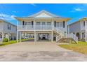 Classic beach house on stilts offering covered parking and a welcoming staircase at 414 32Nd Ave. N, North Myrtle Beach, SC 29582