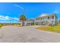 Bright neighborhood street showcasing raised beach homes, lush palms, and sunny skies at 414 32Nd Ave. N, North Myrtle Beach, SC 29582