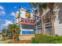 The Dunes Village Resort sign features vibrant colors, nearby palm trees, and tropical landscaping at 5300 N Ocean Blvd. # 422, Myrtle Beach, SC 29572