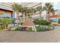 Beautifully landscaped resort entrance with a fountain, palm trees, and colorful flowers for a vibrant welcome at 5300 N Ocean Blvd. # 518, Myrtle Beach, SC 29577