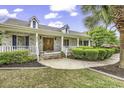 Charming home features a brick facade, inviting porch, and beautifully landscaped front yard at 552 Enoree Ct., Myrtle Beach, SC 29588