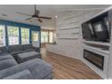 The living room features a decorative wall feature, wood-look flooring, and a comfortable gray sectional at 601 Blue Daisy Ct., Loris, SC 29569