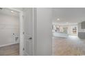 Open-concept interior view with a laundry closet, gray cabinets, wood-look floors, and plenty of natural light at 631 Culmen Ct., Myrtle Beach, SC 29588