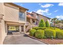 Beautiful condo exterior with well-kept landscaping, a covered garage, and stairs to the entrance at 66 Lakeview Circle # 106, Pawleys Island, SC 29585