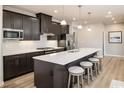 Modern kitchen boasts a large island with seating, sleek cabinets, stainless steel appliances, and hardwood floors at 7075 Denim Loop, Myrtle Beach, SC 29579