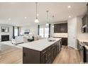 Open-concept kitchen with a large island, dark cabinetry, stainless steel appliances, and hardwood floors at 7075 Denim Loop, Myrtle Beach, SC 29579