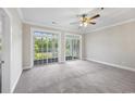 Bright bedroom featuring plush carpet, ceiling fan, and sliding glass doors to an outdoor balcony at 901 Knoll Shores Ct. # 304, Murrells Inlet, SC 29576