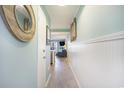 Hallway with pale blue walls and wood-look floors leading to the living area at 9581 Shore Dr. # 216, Myrtle Beach, SC 29572