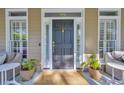 Elegant front door with sidelights, decorative house number, and potted plants adding charm at 99 Berry Tree Dr., Pawleys Island, SC 29585