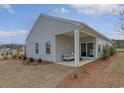 View of a covered back porch with a stylish outdoor seating area and sliding glass door at 1013 Hainer Place Dr, Conway, SC 29526