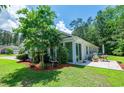 Backyard view of home with a Florida room, patio and a well-maintained lawn at 111 Rose Water Loop # 111, Myrtle Beach, SC 29588