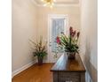Close-up of foyer with hardwood floors, front door with blinds, and decorative plants at 1434 Chanson Ct., Little River, SC 29566