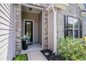 Inviting front entrance featuring a black door, brick accents, and manicured landscaping at 1434 Chanson Ct., Little River, SC 29566