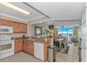 Open concept kitchen with stainless sink, wood cabinets, and granite countertops providing ample space for cooking at 1625 S Ocean Blvd. # 1210, North Myrtle Beach, SC 29582