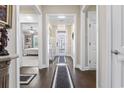 Welcoming hallway with elegant chandelier, dark floors, and decorative light-colored walls at 1681 Suncrest Dr., Myrtle Beach, SC 29577