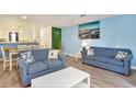 Inviting living room with comfortable blue sofas and a view into the adjacent dining area at 209 75Th Ave N # T-8, Myrtle Beach, SC 29572