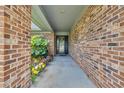 Inviting covered entry with decorative plants, brick columns, and a glimpse of the front door at 215 Lander Dr., Conway, SC 29526