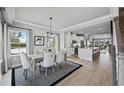 Bright dining area with a chandelier, wood floors, and a view into the kitchen and living spaces at 2616 Elowen Ln. # 167B, Longs, SC 29568