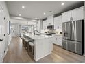 Open concept kitchen with white cabinets, stainless steel appliances, and a large island with seating at 2616 Elowen Ln. # 167B, Longs, SC 29568