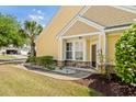 Home's inviting front porch with stone accents, lush landscaping, and manicured lawn at 306 River Rock Ln. # 1306, Murrells Inlet, SC 29576