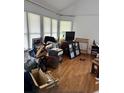 Sunlit living room showcasing hardwood floors and large windows at 3293 Schoolhouse Dr., Hemingway, SC 29554