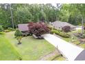An aerial view of a home with lush landscaping and a long driveway leading to the main house and a secondary dwelling at 33 Brassie Dr., Carolina Shores, NC 28467