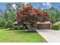 Attractive brick home featuring a well-kept lawn, mature landscaping, and an attached two-car garage with brown door at 33 Brassie Dr., Carolina Shores, NC 28467