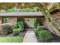 Inviting front entrance with double doors, lush landscaping, brick facade, and a welcoming pathway at 33 Brassie Dr., Carolina Shores, NC 28467