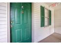 Condo front door with green paint, gold accents, and decorative shutters on an adjacent window at 342 Pinehurst Ln. # 12J, Pawleys Island, SC 29585