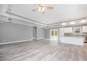 Open-concept living room with tray ceiling, wood-look floors, and view into kitchen at 357 Log Cabin Rd., Loris, SC 29569