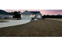 Lovely home at twilight features light blue siding, a two-car garage, and a spacious front lawn at 375 Log Cabin Rd., Loris, SC 29569