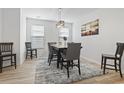 Well-lit dining room featuring modern chandelier, neutral walls and wood-look floors at 452 Sun Colony Blvd., Longs, SC 29568