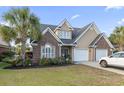 Charming two-story home featuring brick accents, a two-car garage, and mature landscaping at 523 Stonemason Dr., Myrtle Beach, SC 29579