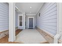 Covered front porch featuring a modern front door and brick accents at 6591 Cagliari Court, Myrtle Beach, SC 29572
