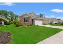 Well-kept home exterior features brick accents, a two-car garage, and lush green lawn at 662 Wallace Dr., Little River, SC 29566