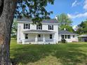 Charming home with a covered porch, black shutters, and green grass on a sunny day at 675 Liberty Church Rd., Loris, SC 29569