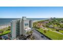 An aerial view of The Beach House Resort with the ocean and the shoreline visible, clear blue skies, and sunny weather at 6804 N Ocean Blvd. # 1049, Myrtle Beach, SC 29572