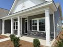 Inviting exterior of the home with a covered porch, gray siding, and manicured landscaping at 1037 Jase Dr., Longs, SC 29568